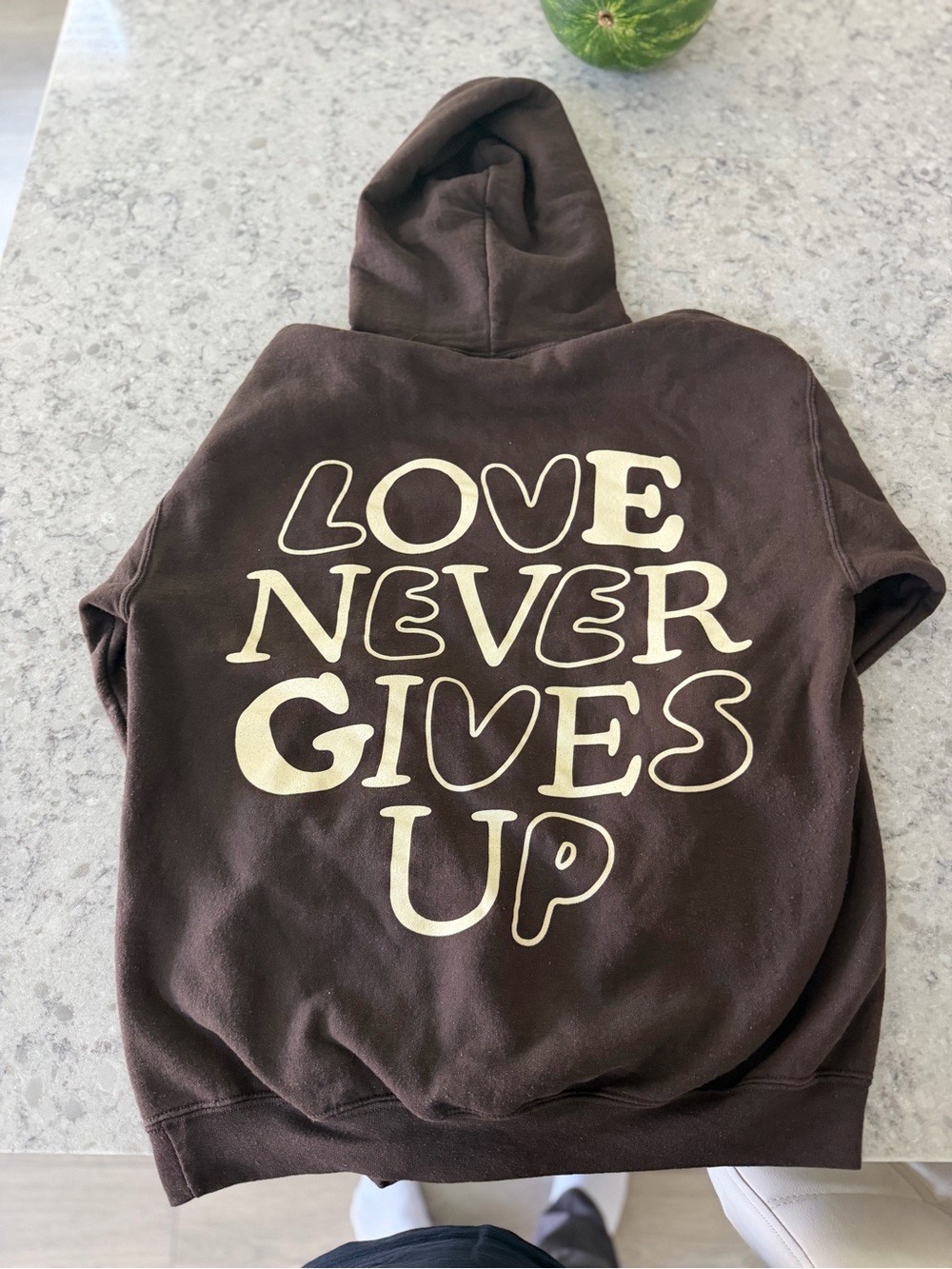 Brown Hoodie with "LOVE NEVER GIVES UP" Graphic